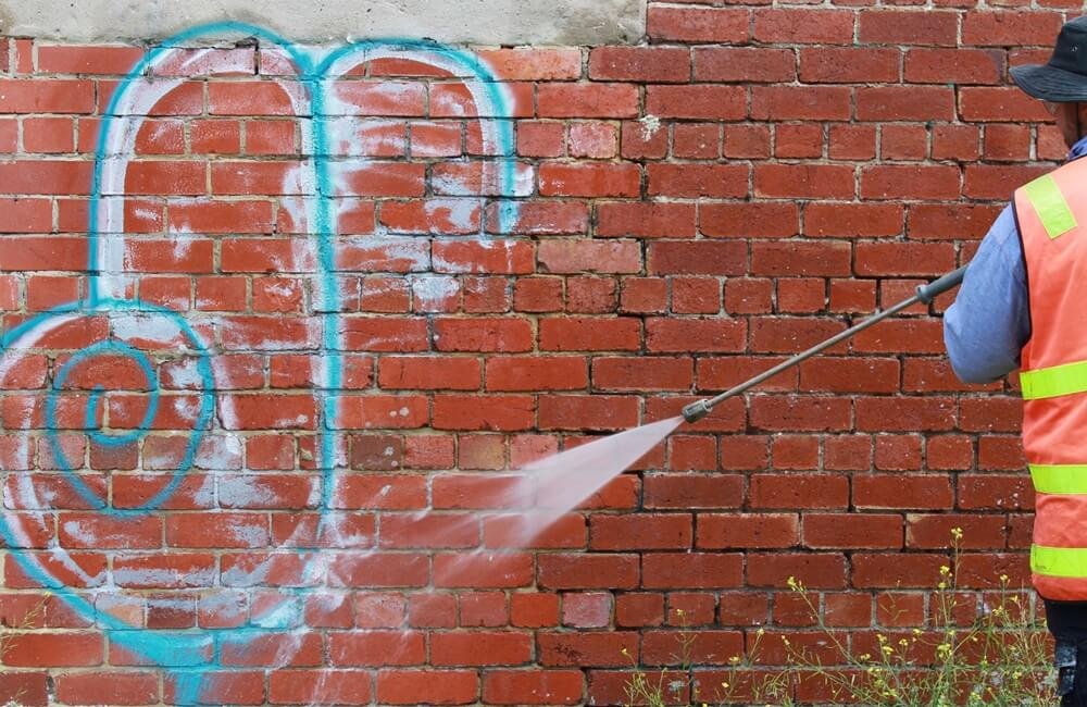 Removing graffiti from a brick wall in Bristol