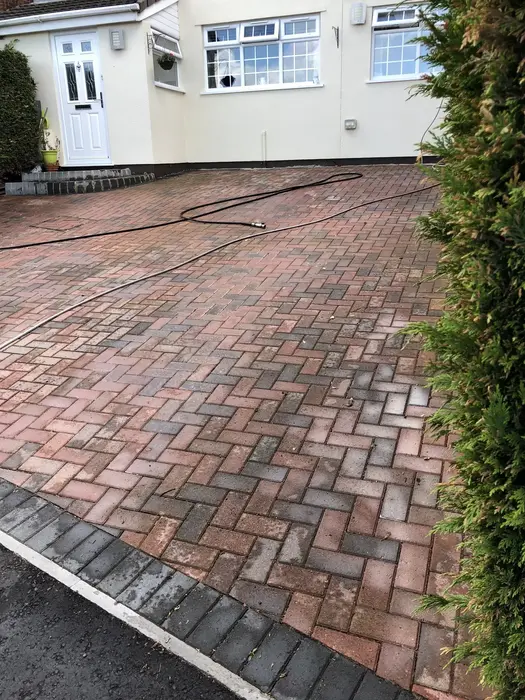 Driveway block paving covered in moss, weeds and lichen before professional pressure washing in Clifton, Bristol
