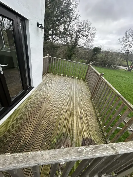 Wooden garden decking covered in green algae and grime before professional pressure washing in Nailsea