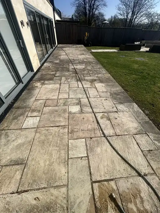Indian sandstone patio discoloured with black algae and moss before specialist cleaning in Clifton, Bristol